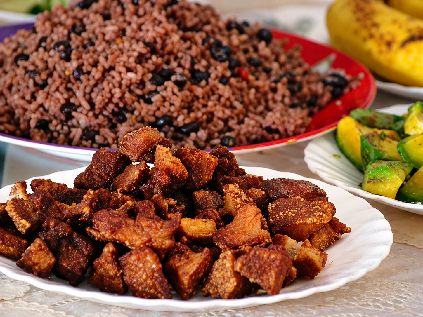 Жареное мясо, рис с фасолью и овощи на тарелках, Гавана, Куба