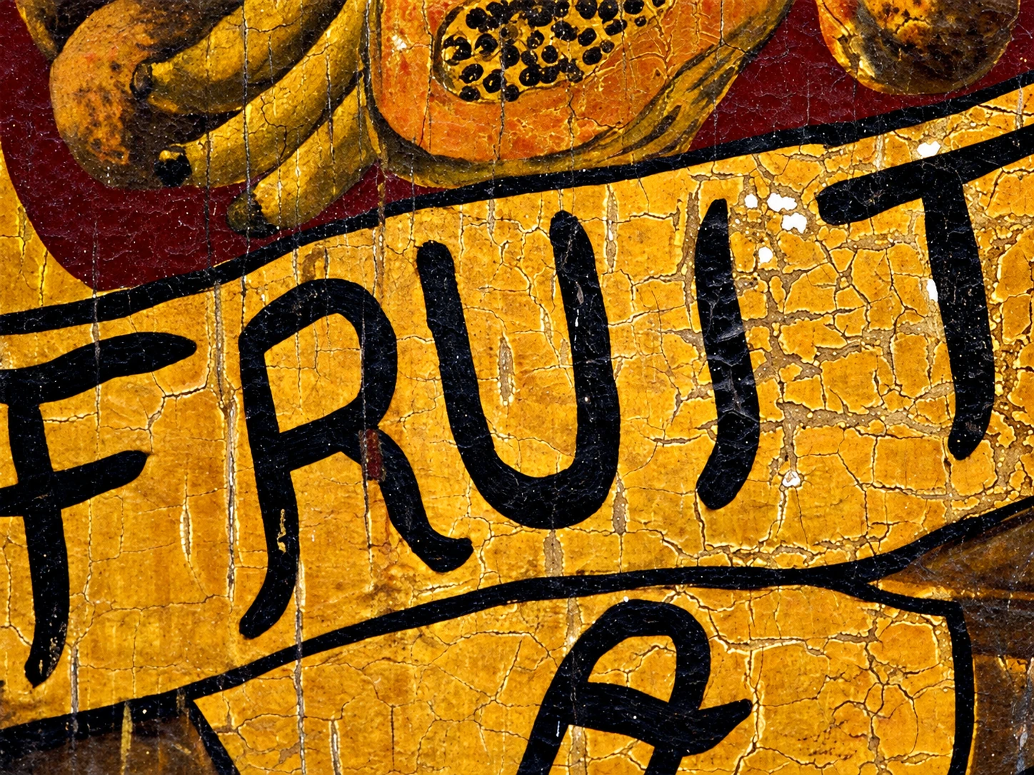 Жёлтая вывеска с надписью FRUIT и рисунками фруктов